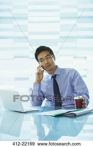 Businessman using laptop in office building cafe View Large Photo Image Stock Photo - Businessman using laptop in office building cafe. Fotosearch