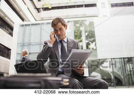 Stock Photo - Businessman working on bench in office building. Fotosearch