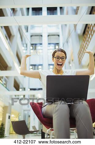 Businesswoman getting excited in office building View Large Photo Image Stock Photo - Businesswoman getting excited in office building. Fotosearch