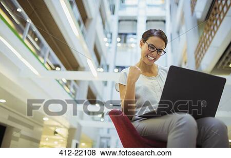 Businesswoman getting excited in office building View Large Photo Image Stock Photo - Businesswoman getting excited in office building. Fotosearch