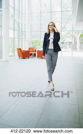 Businesswoman talking on cell phone in office building View Large Photo Image Stock Image - Businesswoman talking on cell phone in office building. Fotosearch