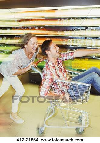 Picture - Blurred view of couple playing in grocery store. Fotosearch