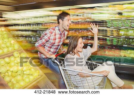 Blurred view of couple playing in grocery store View Large Photo Image Stock Photo - Blurred view of couple playing in grocery store. Fotosearch