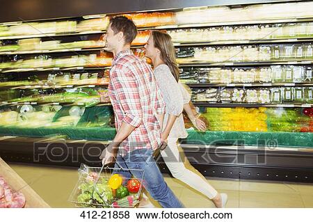 Blurred view of couple shopping together in grocery store View Large Photo Image Stock Photo - Blurred view of couple shopping together in grocery store. Fotosearch