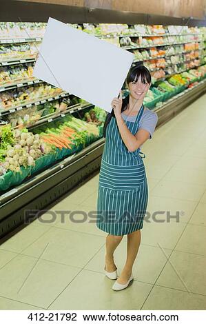 Clerk holding blank card in grocery store produce section View Large Photo Image Stock Image - Clerk holding blank card in grocery store produce section. Fotosearch