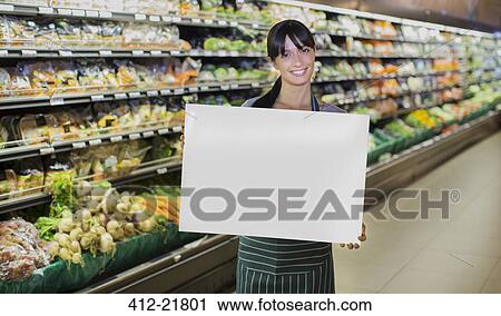 Clerk holding blank card in produce section of grocery store View Large Photo Image Stock Image - Clerk holding blank card in produce section of grocery store. Fotosearch