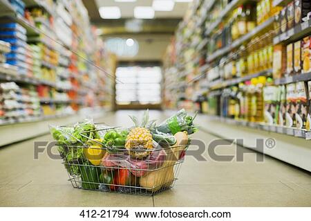 Close up of full shopping basket on floor of grocery store View Large Photo Image Picture - Close up of full shopping basket on floor of grocery store. Fotosearch