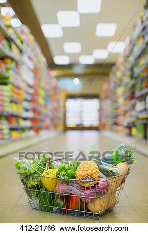 Close up of full shopping basket on floor of grocery store View Large Photo Image Stock Photograph - Close up of full shopping basket on floor of grocery store. Fotosearch
