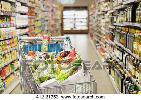 Stock Image - Close up of full shopping cart in grocery store. Fotosearch