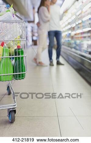 Defocussed view of couple shopping together in grocery store View Large Photo Image Stock Photo - Defocussed view of couple shopping together in grocery store. Fotosearch