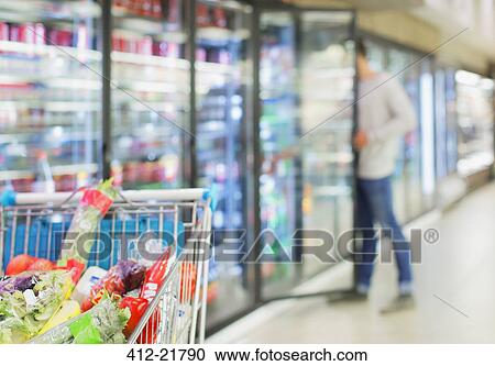 Defocussed view of man shopping in grocery store View Large Photo Image Stock Image - Defocussed view of man shopping in grocery store. Fotosearch