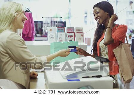 Stock Image - Woman paying with credit card in store. Fotosearch