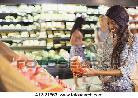 Woman shopping for produce in grocery store View Large Photo Image Stock Image - Woman shopping for produce in grocery store. Fotosearch