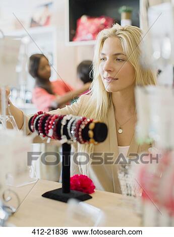 Woman shopping in clothing store View Large Photo Image Stock Photograph - Woman shopping in clothing store. Fotosearch