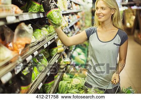 Stock Photo - Woman shopping in grocery store. Fotosearch