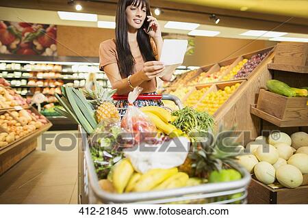 Woman talking on cell phone in grocery store View Large Photo Image Stock Photography - Woman talking on cell phone in grocery store. Fotosearch