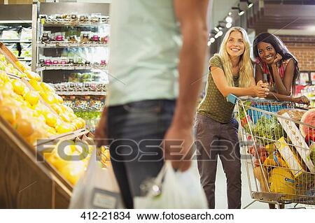 Women admiring man shopping in grocery store View Large Photo Image Picture - Women admiring man shopping in grocery store. Fotosearch