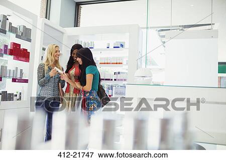 Stock Photo - Women discussing skincare products in drugstore. Fotosearch