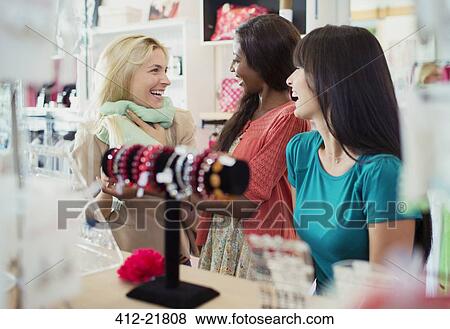 Women shopping together in clothing store View Large Photo Image Stock Photo - Women shopping together in clothing store. Fotosearch