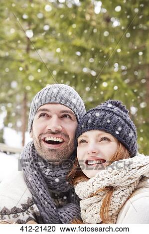 Couple admiring snow together View Large Photo Image Stock Image - Couple admiring snow together. Fotosearch