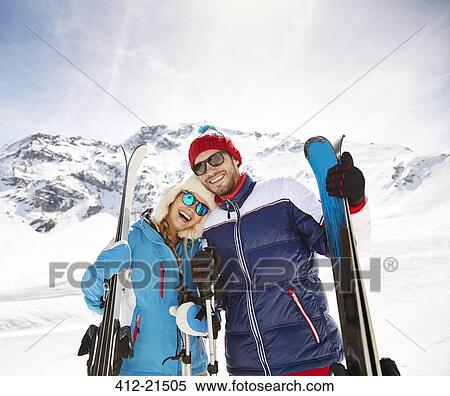 Couple carrying skis on mountain View Large Photo Image Stock Photography - Couple carrying skis on mountain. Fotosearch