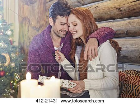 Couple exchanging gifts on Christmas View Large Photo Image Stock Image - Couple exchanging gifts on Christmas. Fotosearch