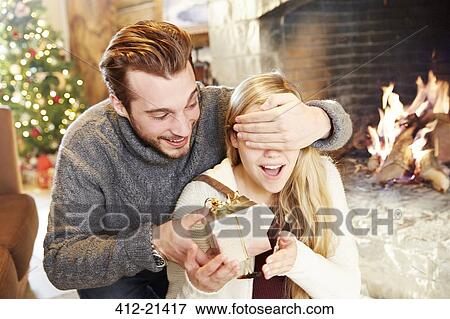 Stock Photo - Couple exchanging gifts on Christmas. Fotosearch