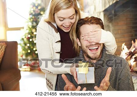 Stock Photography - Couple exchanging gifts on Christmas. Fotosearch