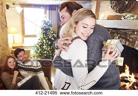 Stock Photography - Couple exchanging gifts on Christmas. Fotosearch