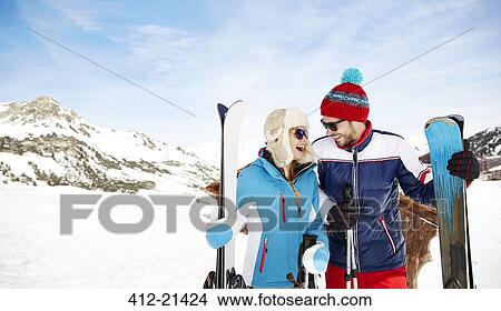Picture - Couple holding skis together. Fotosearch