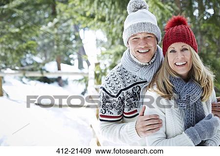 Stock Photo - Couple hugging in snow. Fotosearch