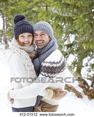 Stock Image - Couple hugging in the snow . Fotosearch