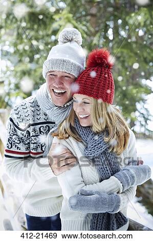 Stock Photo - Couple hugging in the snow together. Fotosearch