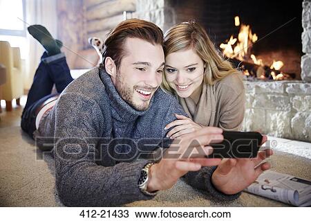 Couple looking at cell phone together View Large Photo Image Stock Image - Couple looking at cell phone together. Fotosearch