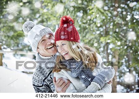 Stock Photograph - Couple playing in snow together. Fotosearch