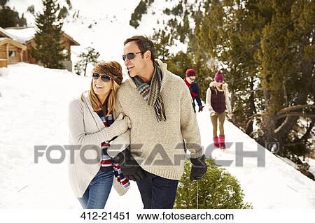 Stock Image - Couple walking through snow together. Fotosearch