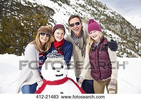Family building a snowman together View Large Photo Image Stock Image - Family building a snowman together. Fotosearch