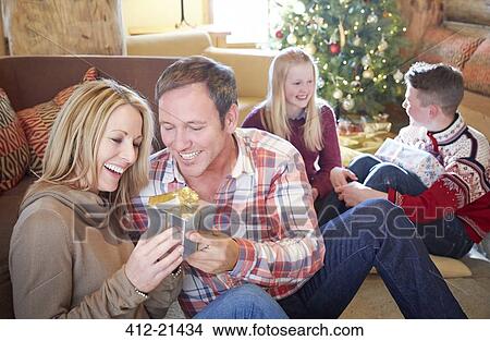 Picture - Family exchanging gifts on Christmas. Fotosearch