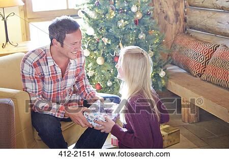 Family exchanging gifts on Christmas View Large Photo Image Picture - Family exchanging gifts on Christmas. Fotosearch
