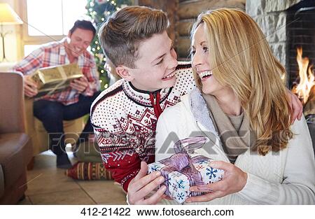 Stock Image - Family exchanging gifts on Christmas. Fotosearch