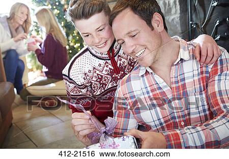 Family exchanging gifts on Christmas View Large Photo Image Stock Photograph - Family exchanging gifts on Christmas. Fotosearch