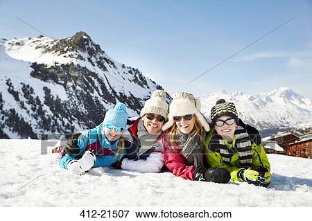 Family laying in the snow together View Large Photo Image Stock Photo - Family laying in the snow together. Fotosearch