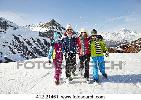 Stock Image - Family walking through snow together. Fotosearch