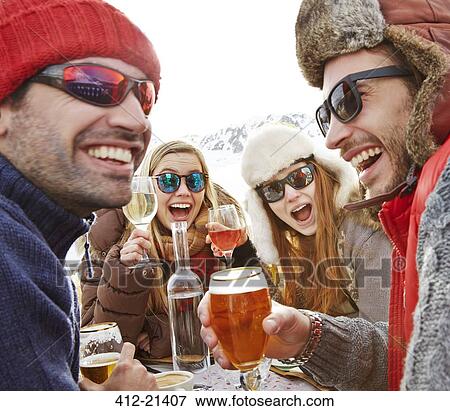 Friends celebrating with drinks in snow View Large Photo Image Stock Photo - Friends celebrating with drinks in snow. Fotosearch