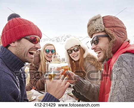 Friends celebrating with drinks in the snow View Large Photo Image Stock Photo - Friends celebrating with drinks in the snow. Fotosearch