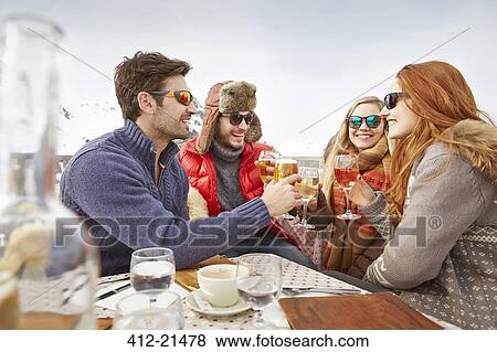 Friends celebrating with drinks in the snow View Large Photo Image Stock Photo - Friends celebrating with drinks in the snow. Fotosearch