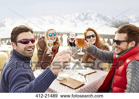 Stock Photo - Friends celebrating with drinks in the snow . Fotosearch