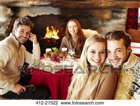 Friends eating together by fireplace View Large Photo Image Stock Image - Friends eating together by fireplace. Fotosearch