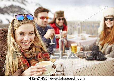 Stock Photography - Friends hacking drinks in the snow together. Fotosearch