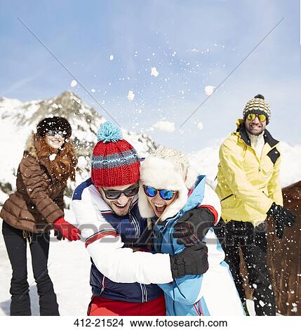Picture - Friends having snowball fight in snow . Fotosearch